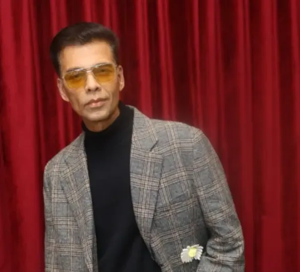 How does Karan Johar cope with online trolls targeting him and his family?