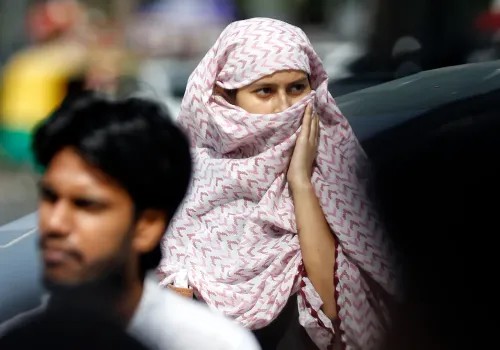 स्कार्फ़ से धूप से बचती दिल्ली की महिला यात्री