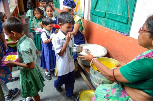 कोलकाता सरकारी स्कूल में मिड डे मील परोसता कर्मचारी