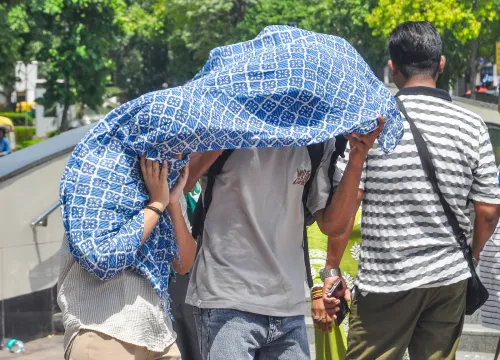 धूप से बचाव: कपड़े से चेहरा ढकते पैदल यात्री