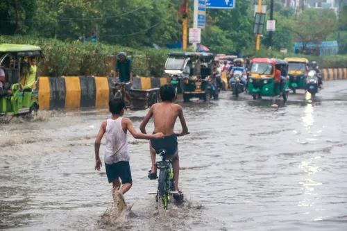 पूर्वी दिल्ली में जलभराव के बीच साइकिल पर बच्चा