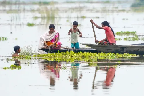 बाढ़ के पानी में मछली पकड़तीं मोरीगाँव की महिलाएँ और बच्चे