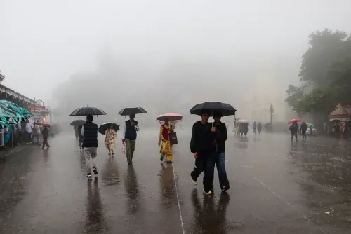 रिज मैदान पर बारिश में छाते लेकर गुज़रते लोग