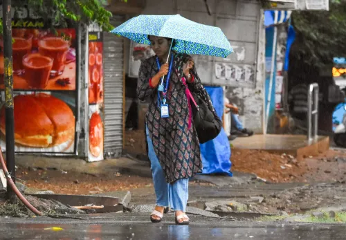 छाते थामे महिला — बेंगलुरु में मूसलाधार बारिश