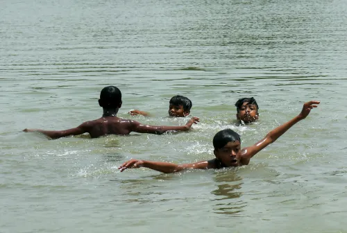 New Delhi: Children cool off in pond amid heat